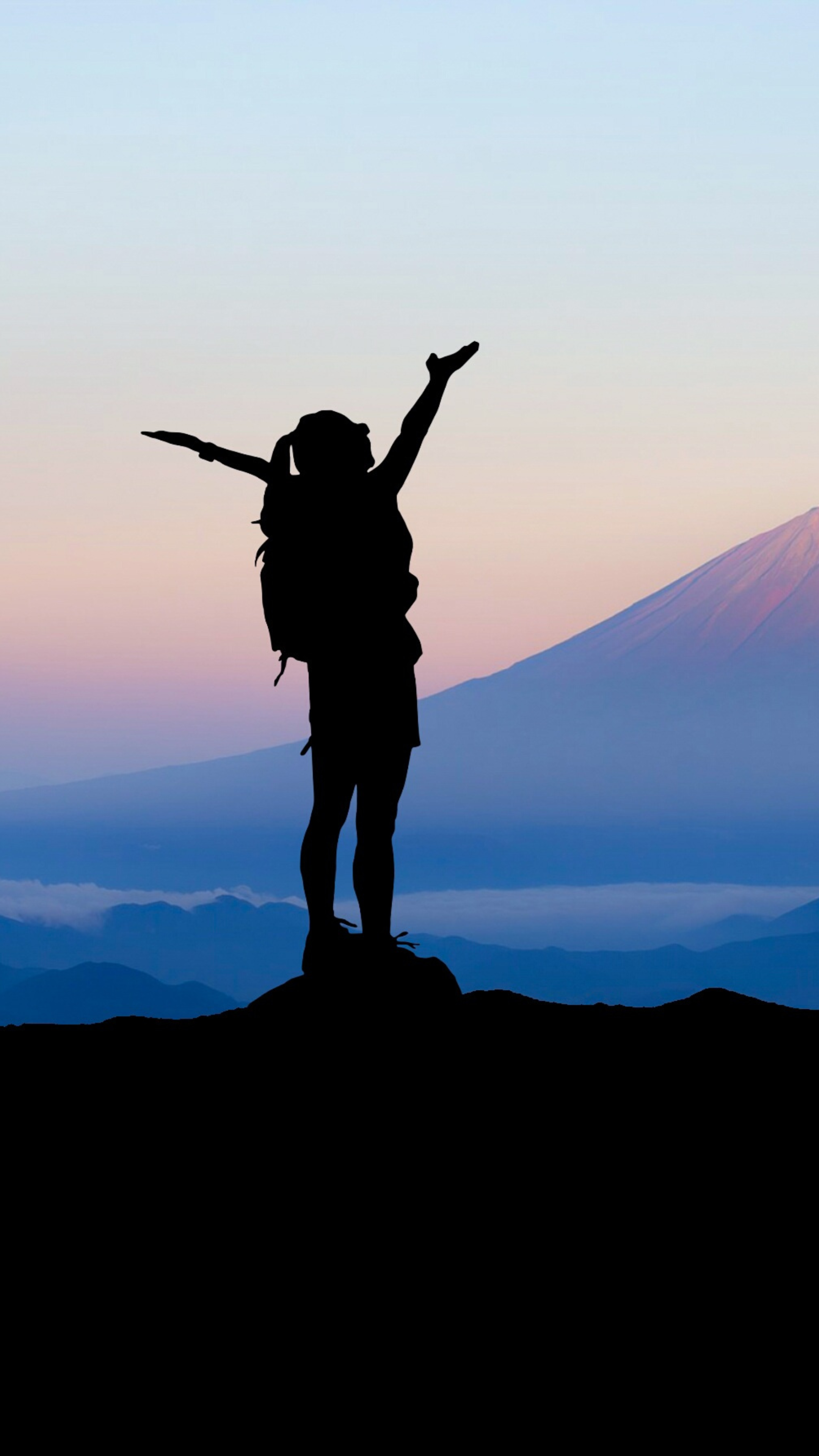 A woman celebrating achievement with The Success Society, standing on top of a mountain.